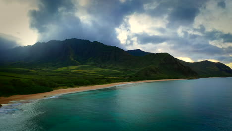 Man-alone-on-amazing-beach-with-dramatic-ridges-in-background,-aerial,-Oahu