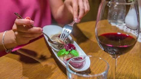 Woman-eating-delicious-ice-cream-dessert-with-glass-of-red-wine