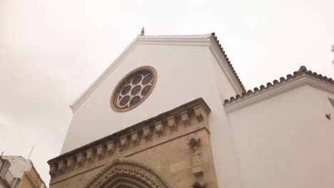 Tilt-up-of-historic-Santa-Catalina-Church-in-Seville,-Spain-on-rainy-day