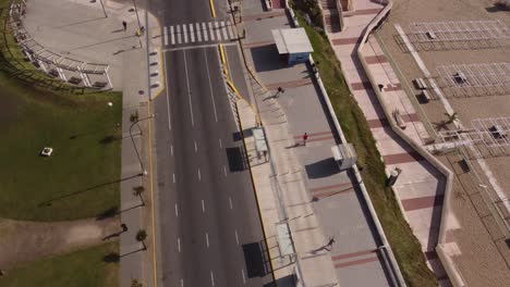 Luftaufnahme-Eines-Läufers,-Der-An-Sonnigen-Tagen-In-Der-Stadt-Mar-Del-Plata,-Argentinien,-Auf-Der-Strandpromenade-Neben-Der-Straße-Läuft