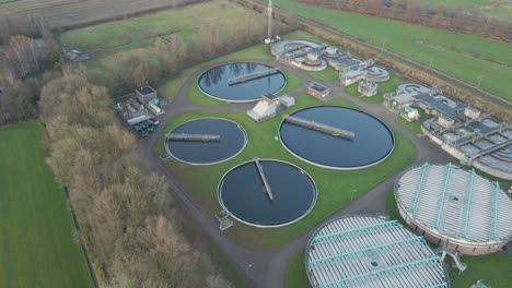 Flying-away-from-large-water-tanks-on-terrain-of-sewage-water-treatment-plant