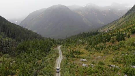 Aerial-following-vehicle-driving-dirt-road-through-British-Columbia-mountains