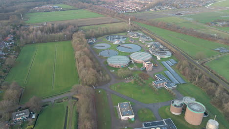 Aerial-of-sewage-water-treatment-plant-with-waste-water-flowing-through-aeration-tank---drone-flying-backwards