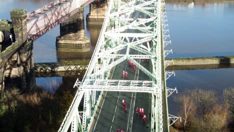 Charity-Santa-dash-fun-run-over-Runcorn-Silver-Jubilee-bridge-Aerial-view-fast-tilting-up