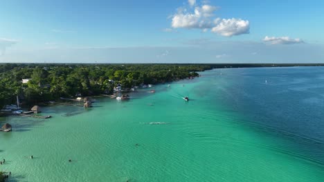 Aerial-view-of-coastline-of-the-Bacalar-town,-in-sunny-Mexico---rising,-drone-shot