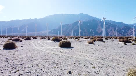 Supply-of-green-made-electric-energy-by-wind-turbines-in-California-desert-area,-fly-forward-view