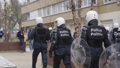 Policías-Antidisturbios-Acercándose-Lentamente-A-Un-Grupo-De-Manifestantes,-Cámara-Lenta