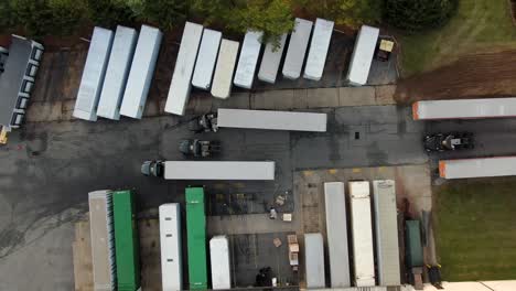 Top-down-aerial-drone-view-of-freight-trailers-at-distribution-center,-logistics-and-transportation,-e-commerce-theme