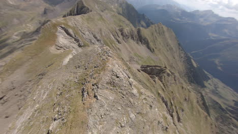 Spinning-FPV-aerial-view-above-Esterri-D'aneu-majestic-eroded-mountain-slope,-Catalonia
