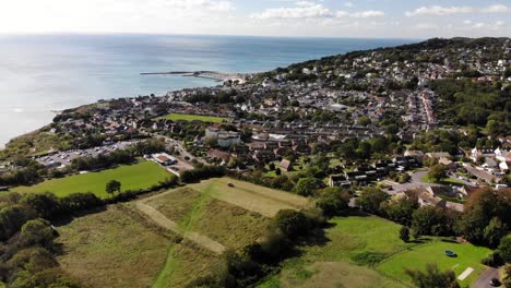 Aerial-Over-Fields-With-View-Of-Lyme-Regis-Town-In-Background