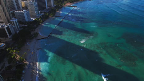 Aerial-view-of-Waikiki-beach-with-green-water-and-resorts---tilt-up-to-Diamond-Head