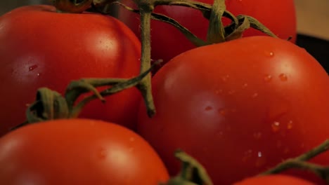 Eine-Nahaufnahme-In-Zeitlupe-Von-Einigen-Tomaten,-Die-Sich-Drehen,-Mit-Einigen-Kleinen-Wassertropfen-Auf-Ihrer-Haut