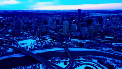 4k-Twilight-Winter-Snow-Antenne-Pan-Out-Downtown-Edmonton-Südöstlicher-Talrand-Mit-Blick-Auf-Den-North-Saskatchewan-River-Reflexion-Von-Autos,-Die-Die-Niedrige-Scona-Und-Die-Connors-Rd-98-Ave-Bridges-2-2-überqueren