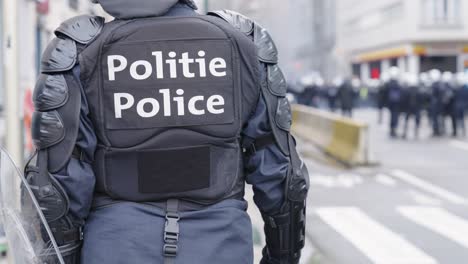 A-Belgian-police-officer-in-riot-gear-standing-on-an-urban-street-awaiting-orders