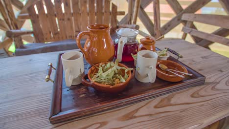 Breakfast-tray-with-tea-and-mugs-on-a-wooden-table,-Vacation-breakfast-concept,-Dolly-shot