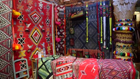 Colorful-carpet-and-textiles-stand-in-the-souks-streets,-Tunisian-traditional-objects