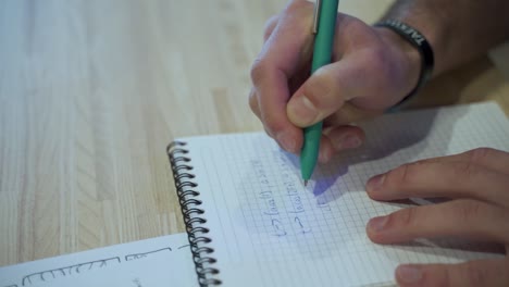 Männliche-Hände-Schreiben-In-Notizbuch