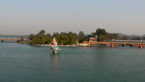 Estatua-De-Dios-Hindú-Y-Puente-De-Cable-Aislado-Sobre-El-Río-Ganges-Desde-Atrás-Con-Cielo-Azul-Brillante-Video-Tomado-En-Haridwar-Uttrakhand-India-El-15-De-Marzo-De-2022