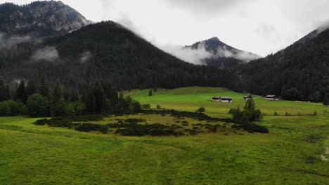 Summer-rain-in-quiet-alpine-valley,-scenic-mountain-landscape,-aerial-view