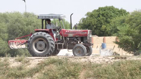 Aufnahme-Eines-Mannes,-Der-Einen-Traktor-Auf-Dem-Ackerland-Von-Pakistan-Fährt