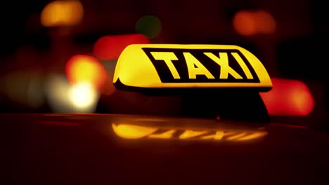 Taxi-light-on-car-in-night-time-german-street-illuminated-dark-out-of-focus-bokeh-road
