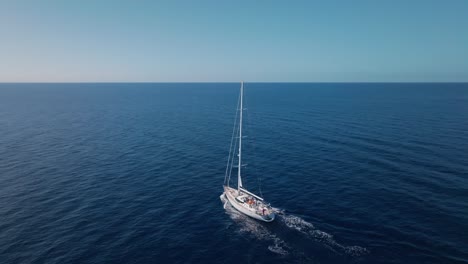 Luxury-white-Oyster-82-yacht-navigating-on-blue-sea-waters-with-horizon-in-background,-sky-for-copy-space