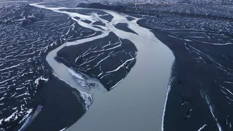 Aerial-flyover-Sula-River-surrounded-by-black-volcanic-basalt-landscape-in-Iceland