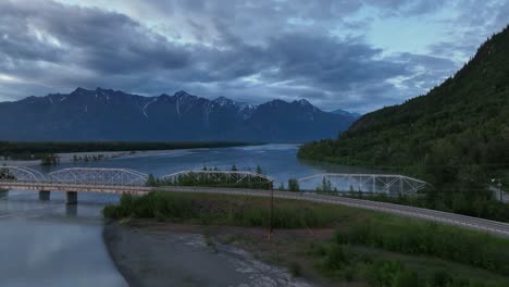 Old-Railway-Bridge-Over-Knik-River-With-Mountain-Backdrop-On-A-Cloudy-Day-In-Palmer,-Alaska