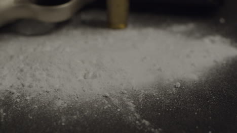 Close-up-of-cocaine-powder-and-a-pistol-and-bullet-on-the-background