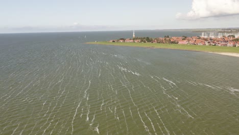 Aerial-shot-approaching-the-scenic-coastal-town-of-Hindeloopen-in-Friesland,-the-Netherlands,-on-a-beautiful-sunny-summer-day
