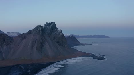 Montaña-Vestrahorn-En-La-Península-De-Stokksnes-En-Islandia,-Vista-Aérea-Que-Revela-La-Montaña-Brunnhorn-En-La-Distancia
