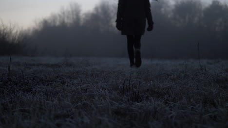 Tilting-from-a-low-angle-following-a-silhouetted-woman-on-a-frosty-morning