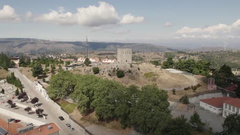 Aerial-orbit-of-the-medieval-Castle-of-Guarda-in-the-homonymous-municipality-on-a-sunny-day-with-the-city-in-the-background---drone-shot