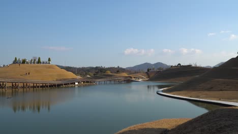 Suncheonman-Bay-Lake-Garden-in-Autumn,-Visitors-walking-on-Bonghwa-Hill-spiral-walkway-trails-and-Bridge-of-Dreams,-Suncheon-city,-Jeonnam,-South-Korea