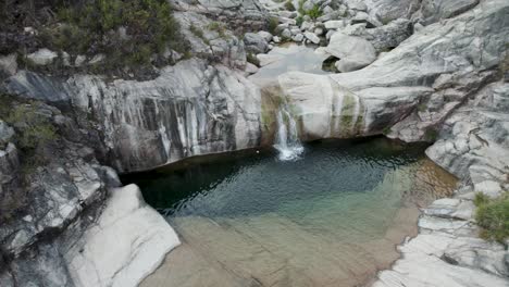 Wunderschöner-Natürlicher-Pool-Mit-Kristallklarem-Wasser,-Der-In-Freier-Wildbahn-Zwischen-Felsen-Geformt-Wurde