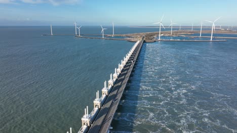 Aerial-slow-motion-shot-of-the-open-Eastern-Scheldt-storm-surge-barrier-and-wind-turbines-on-a-beautiful-sunny-day