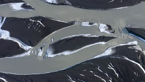 Ascending-aerial-top-down-shot-of-glacial-River-named-Sula-in-Iceland,-flowing-from-Vatnajökull-to-Skeiðarársandur