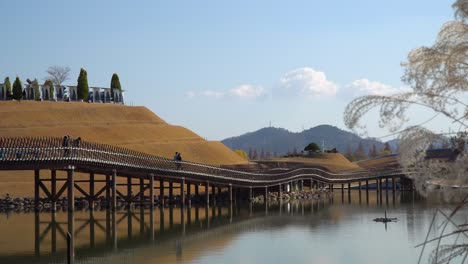 Visitors-sightseen-from-Bridge-of-Dreams-in-Lake-Garden-of-Suncheonman-Bay-National-Garden,-Suncheon-City-Eco-Park,-South-Korea