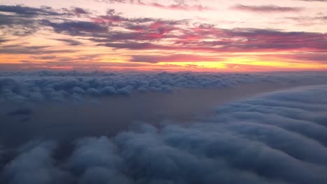 Abstieg-Zu-Den-Wolken-Mit-Einem-Meer-Darunter-Und-Einem-Farbenfrohen-Sonnenuntergang-über-Dem-Horizont