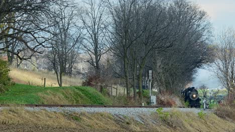 A-View-of-a-Steam-Passenger-Train-Approaching-From-a-Long-Distance-on-a-Cold-Fall-Day-With-Lots-of-Smoke