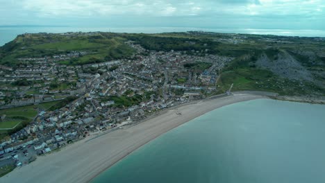 Cinematic-aerial-flying-towards-Fortunswell-and-Underhill-over-Chesil-Beach-on-the-Isle-of-Portland-Dorest-England