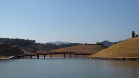 Suncheonman-Bay-National-Garden,-Lake-Garden---Tourists-crossing-Bridge-of-Dreams-and-walking-on-spiral-roads-around-Bonghwa-Hill,-Suncheon,-South-Korea