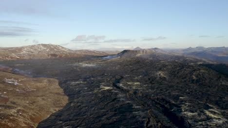 Tiro-De-Dron-Ascendente-Que-Muestra-El-Paisaje-Del-Volcán-Y-Geldingadalir-En-Erupción-Durante-Un-Día-Soleado-Con-Cielo-Azul-En-Islandia