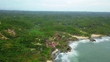 Aerial-view-of-village-on-the-tropical-shoreline-that-overgrown-by-green-trees---Wonosari,-Yogyakarta,-Indonesia
