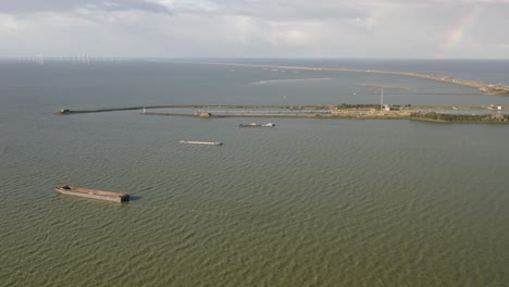 Aerial-shot-of-water-around-the-Afsluitdijk-causeway-in-Kornwerderzand-in-Friesland,-the-Netherlands,-on-a-sunny-day
