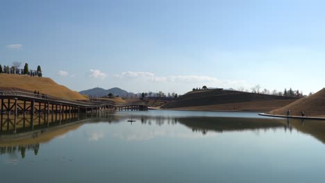 Lake-Garden-with-Bridge-of-Dreams,-Haeryeong,-Bonghwa-Hills-skyline-in-Suncheonman-Bay-National-Garden,-Suncheon,-South-Korea
