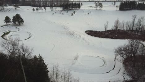 Aufsteigende-Luftaufnahme-Eines-Im-Winter-Mit-Neuschnee-Bedeckten-Golfplatzes