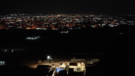 Aerial-flying-forward-over-residential-neighborhood-in-Jeddah-at-night,-Saudi-Arabia