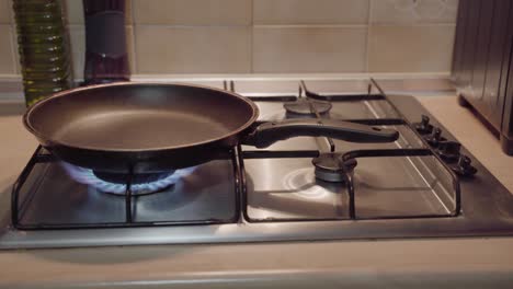 Hand-lighting-gas-stove,-adjusting-frying-pan