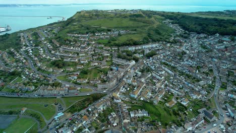 Aerial-pull-out-reveal-over-Underhill-and-Fortuneswell-Village-on-the-Isle-of-Portland-with-Fleet-Lagoon-in-the-background-and-Chesil-Beach-in-the-foreground
